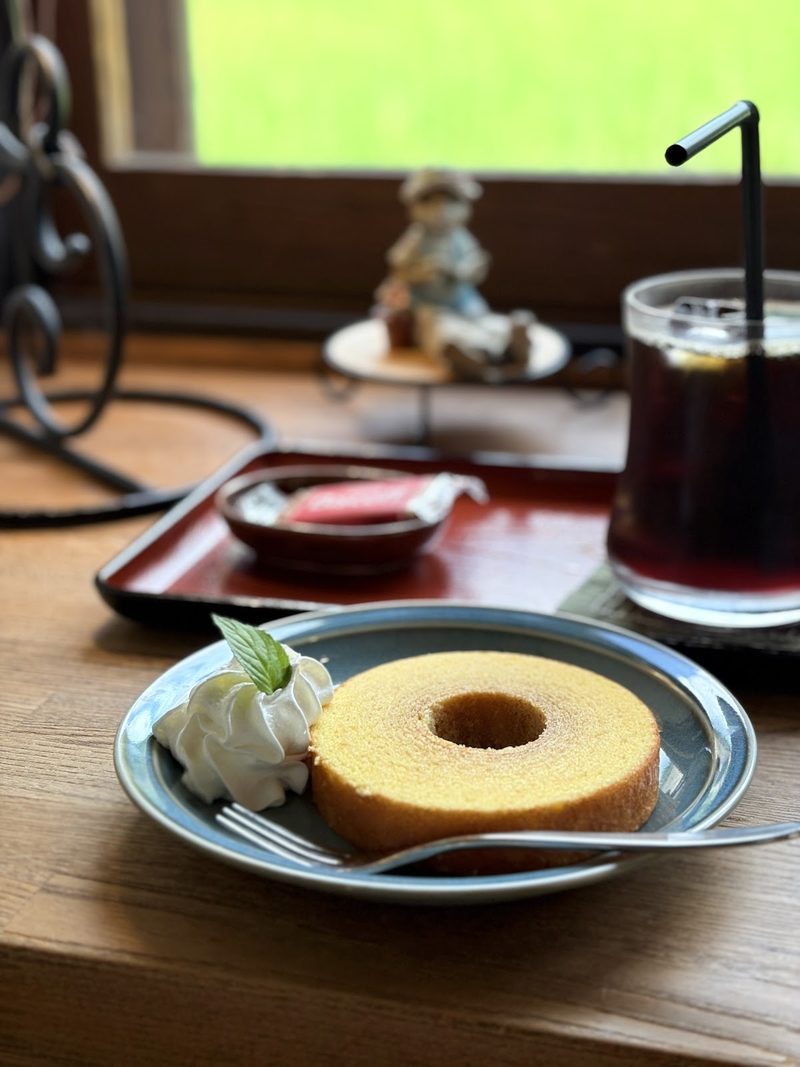 生クリームを添えたバウムクーヘンと、窓辺のアイスコーヒー