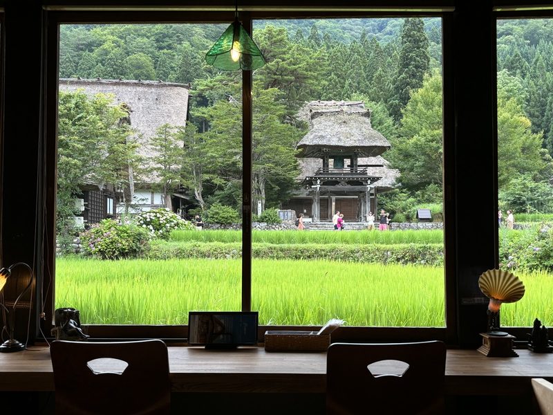 窓の向こうに広がる田んぼと明善寺の鐘楼