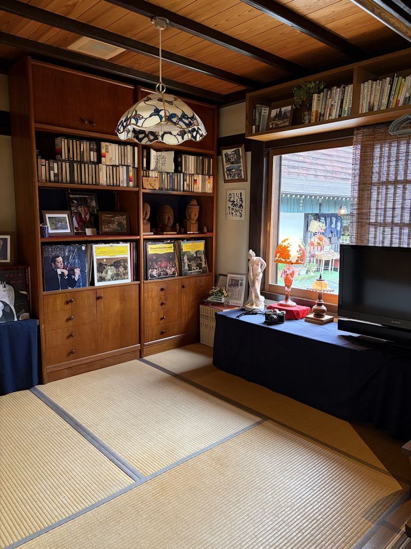 畳の間に置かれた古い木の棚と本棚
